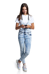 Image showing Smiling teen girl with smart phone in hands,