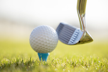 Image showing Golf ball on tee in front of driver