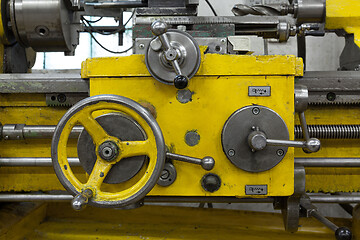 Image showing Old yellow lathe machine with a lot of handles.