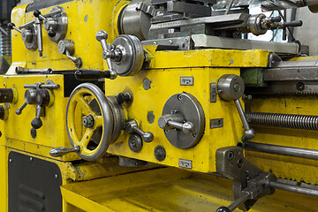 Image showing Old yellow lathe machine with a lot of handles.