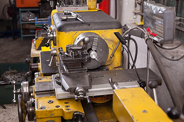 Image showing Old yellow lathe machine with a lot of handles.