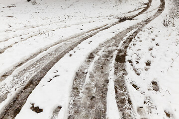 Image showing traces of the wheels of the car on a rural road covered with snow