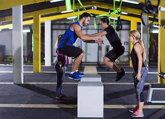 Image showing athletes working out  jumping on fit box