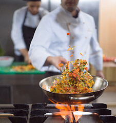 Image showing chef flipping vegetables in wok