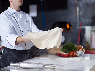 Image showing chef throwing up pizza dough