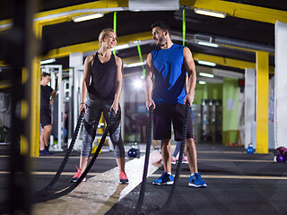 Image showing sports couple doing battle ropes crossfitness exercise