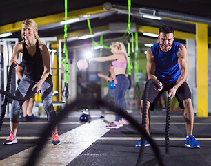 Image showing sports couple doing battle ropes crossfitness exercise