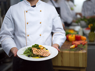 Image showing Chef holding dish of fried Salmon fish fillet