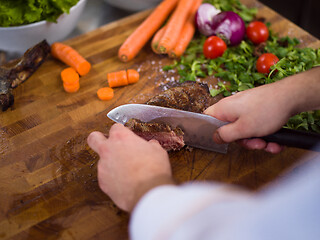 Image showing closeup of Chef hands preparing beef steak