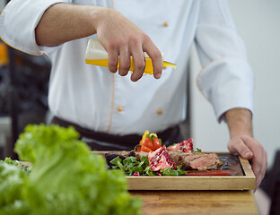 Image showing Chef finishing steak meat plate