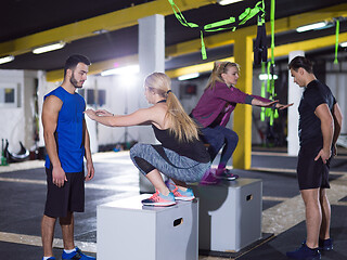 Image showing athletes working out  jumping on fit box