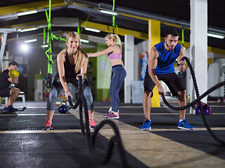 Image showing sports couple doing battle ropes crossfitness exercise