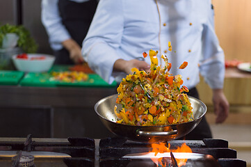 Image showing chef flipping vegetables in wok