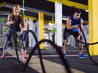 Image showing sports couple doing battle ropes crossfitness exercise