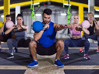 Image showing athletes doing exercises with kettlebells