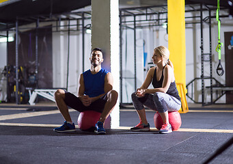 Image showing young athletes sitting on the crossfitness ball and relaxing