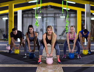 Image showing athletes doing exercises with kettlebells