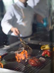 Image showing chef cooking steak with vegetables on a barbecue