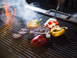 Image showing chef cooking steak with vegetables on a barbecue