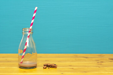 Image showing Straw and bottle with dregs of milkshake, and cookie crumbs