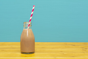 Image showing Chocolate milkshake with a retro straw in a glass bottle