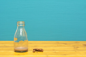 Image showing Milk bottle with dregs of chocolate milkshake and cookie crumbs