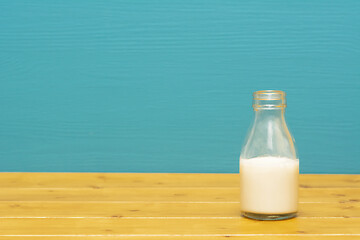 Image showing One-third pint glass bottle half full with fresh creamy milk