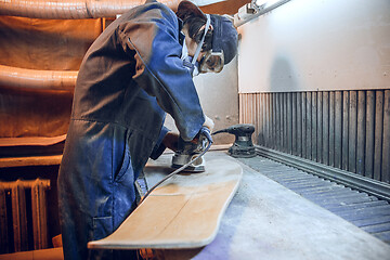 Image showing Carpenter using circular saw for cutting wooden boards.