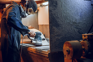 Image showing Carpenter using circular saw for cutting wooden boards.