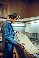 Image showing Portrait of handsome carpenter working with skate at workshop