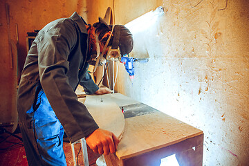 Image showing Portrait of handsome carpenter working with skate at workshop