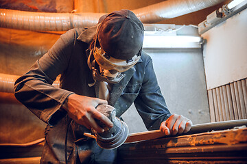 Image showing Carpenter using circular saw for cutting wooden boards.