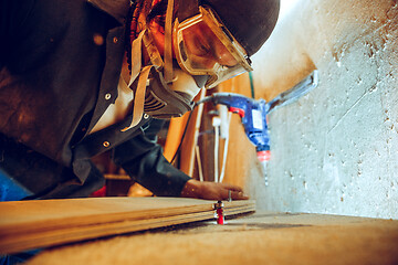 Image showing Portrait of handsome carpenter working with skate at workshop