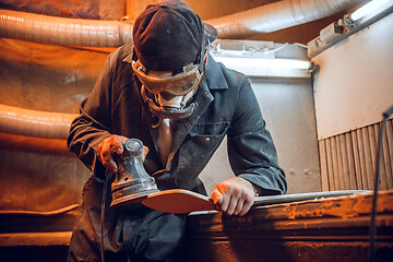 Image showing Carpenter using circular saw for cutting wooden boards.