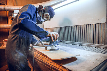 Image showing Carpenter using circular saw for cutting wooden boards.