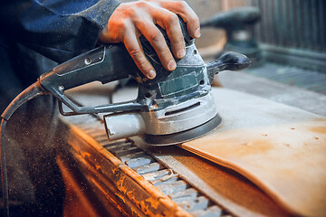 Image showing Carpenter using circular saw for cutting wooden boards.