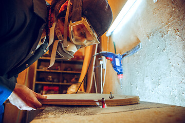 Image showing Portrait of handsome carpenter working with skate at workshop