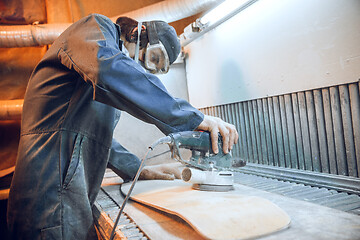 Image showing Carpenter using circular saw for cutting wooden boards.