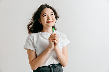 Image showing Smiling young woman looking on pregnancy test