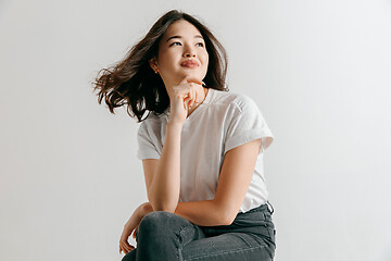 Image showing Happy asian woman standing and smiling against gray background.