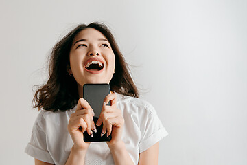 Image showing Portrait of a confident casual asian girl showing blank screen of mobile phone