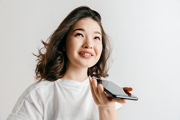 Image showing Indoor portrait of attractive young asian woman holding blank smartphone