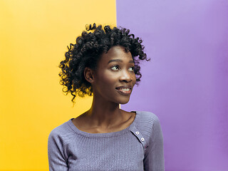 Image showing The happy african woman standing and smiling against gray background.