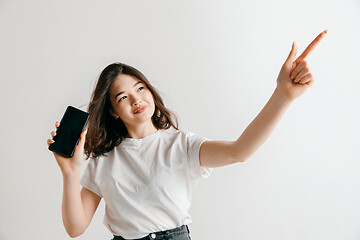 Image showing Portrait of a confident casual asian girl showing blank screen of mobile phone