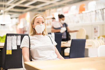 Image showing New normal during covid epidemic. Caucasian woman shopping at retail furniture and home accessories store wearing protective medical face mask to prevent spreading of corona virus