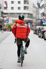 Image showing Courier On Bicycle Delivering Food In City.