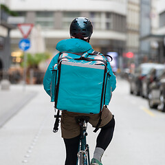 Image showing Courier On Bicycle Delivering Food In City.