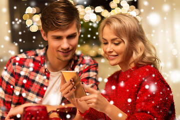 Image showing couple with smartphone at home christmas dinner