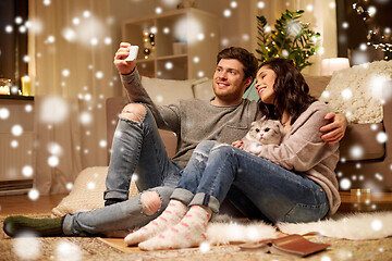 Image showing happy couple taking selfie by smartphone at home