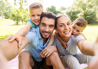 Image showing family having picnic and taking selfie at park